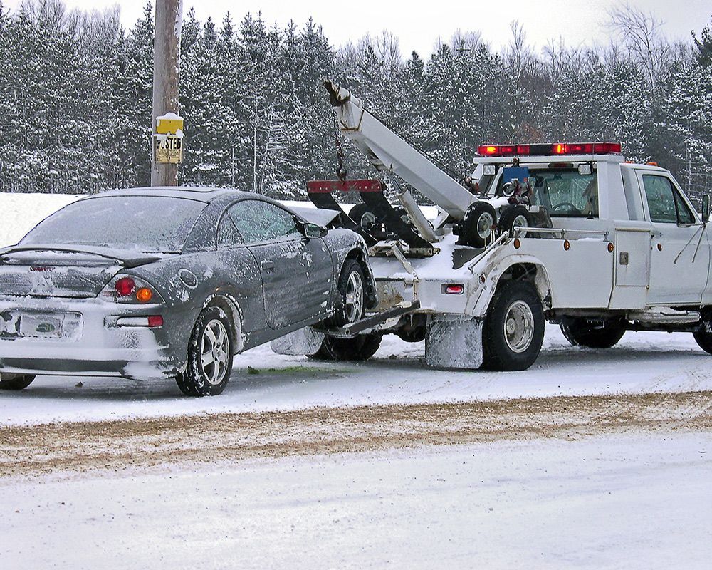 Tow Truck Towing Car on Snowy Area