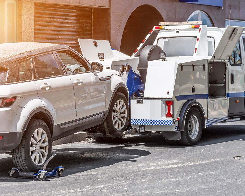 White SUV is being Towed by a Tow Truck