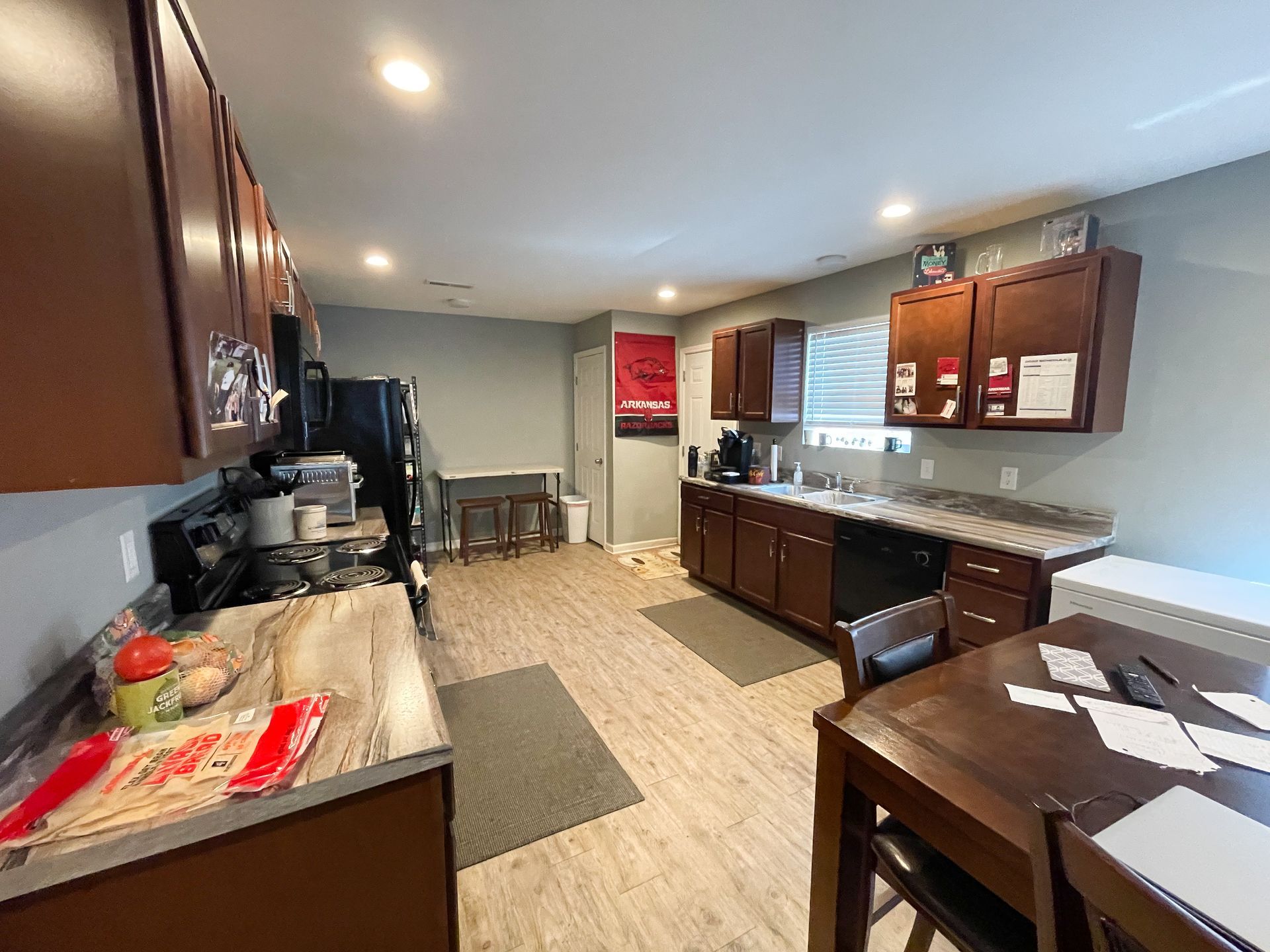 Bright kitchen with dark wood cabinets, granite counters, and a dining table by the window.