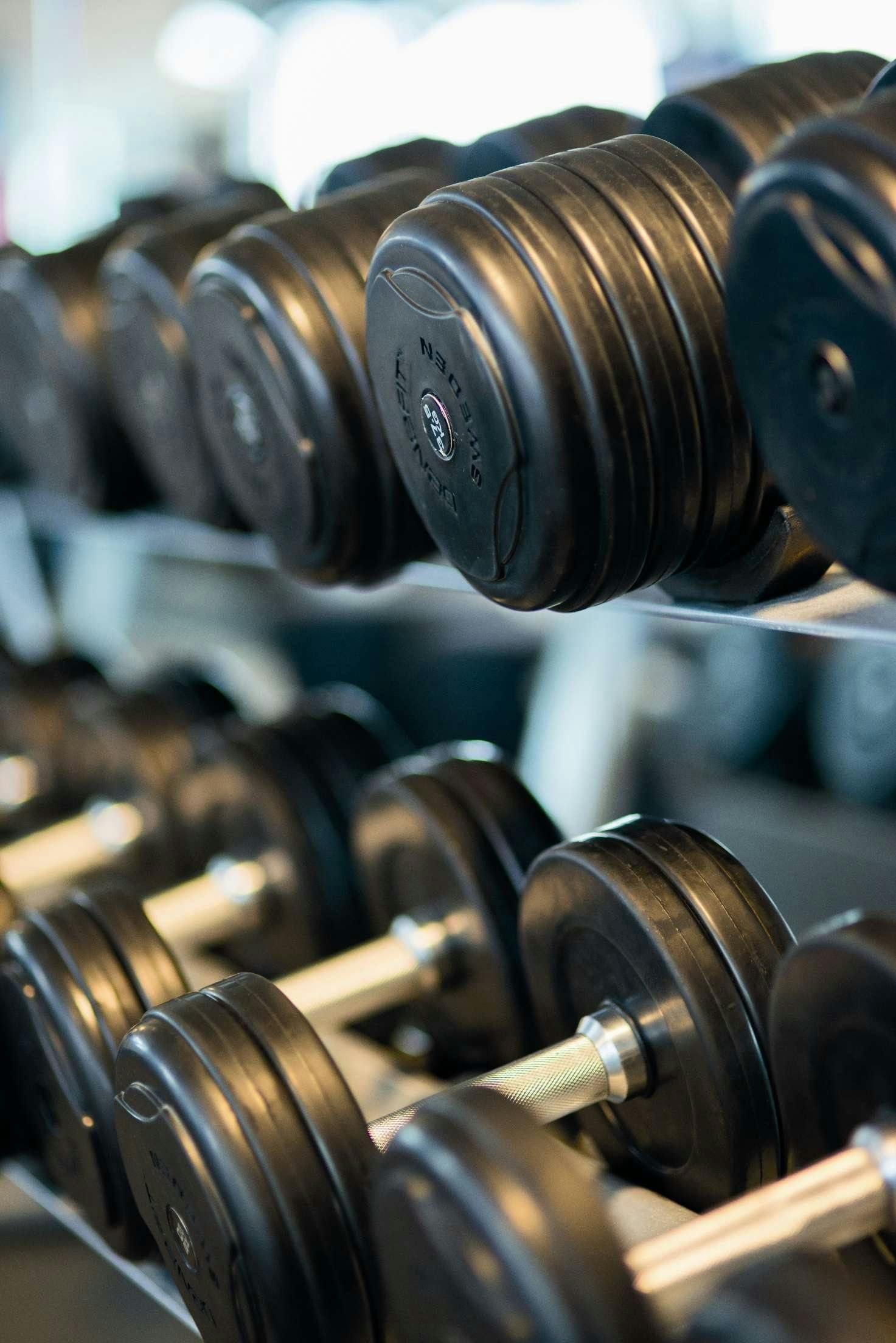 Person lifting barbell in gym, black and white.