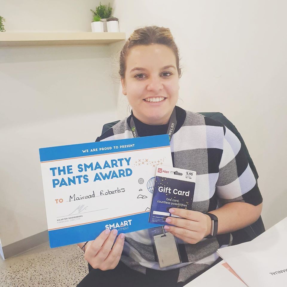 A woman is holding a certificate that says the smaarty pants award