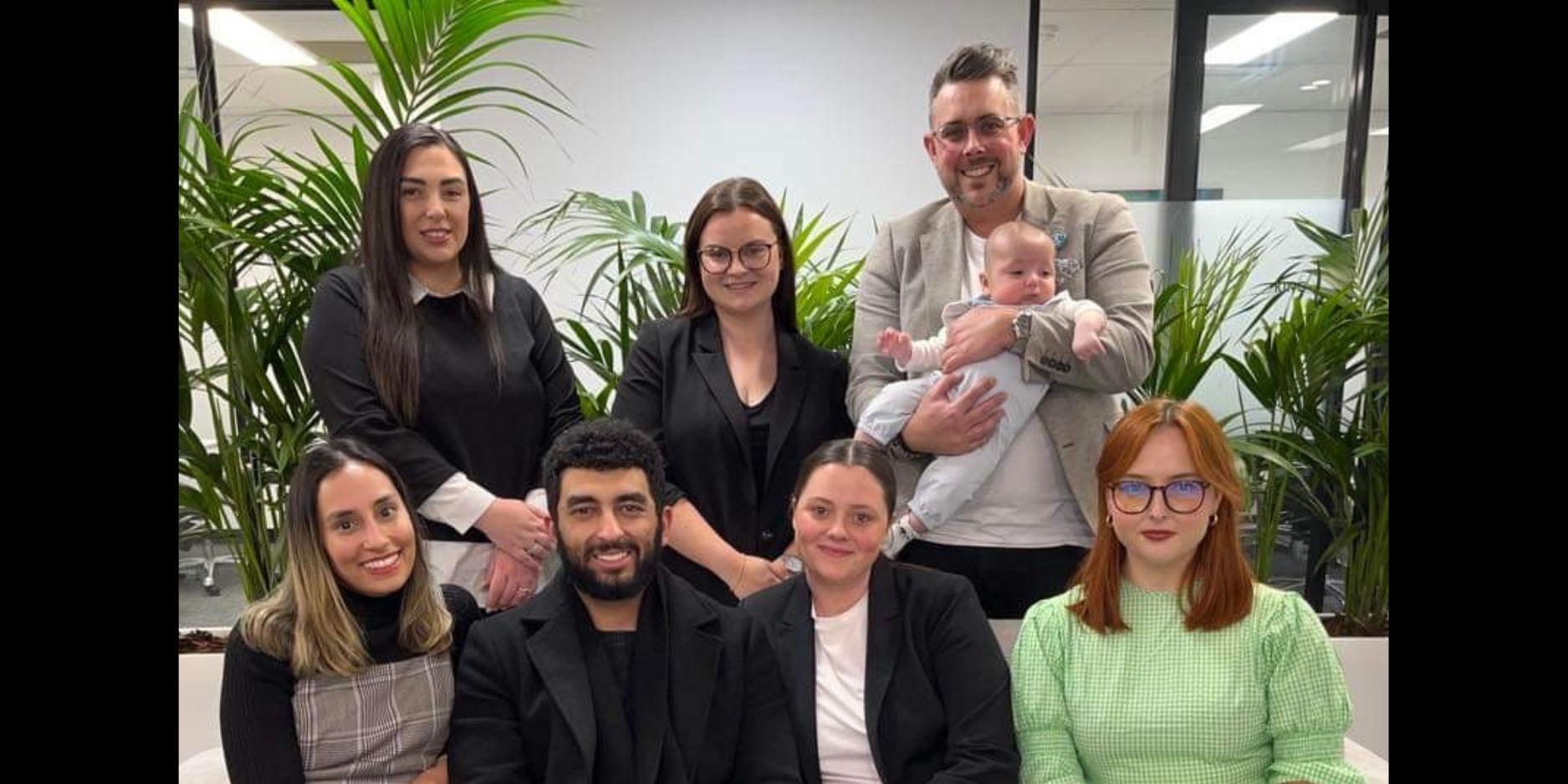 A group of people are posing for a picture with a baby.