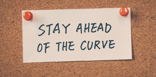 White sticky note on corkboard reads