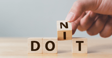 A person is stacking wooden blocks with the word do it on them.