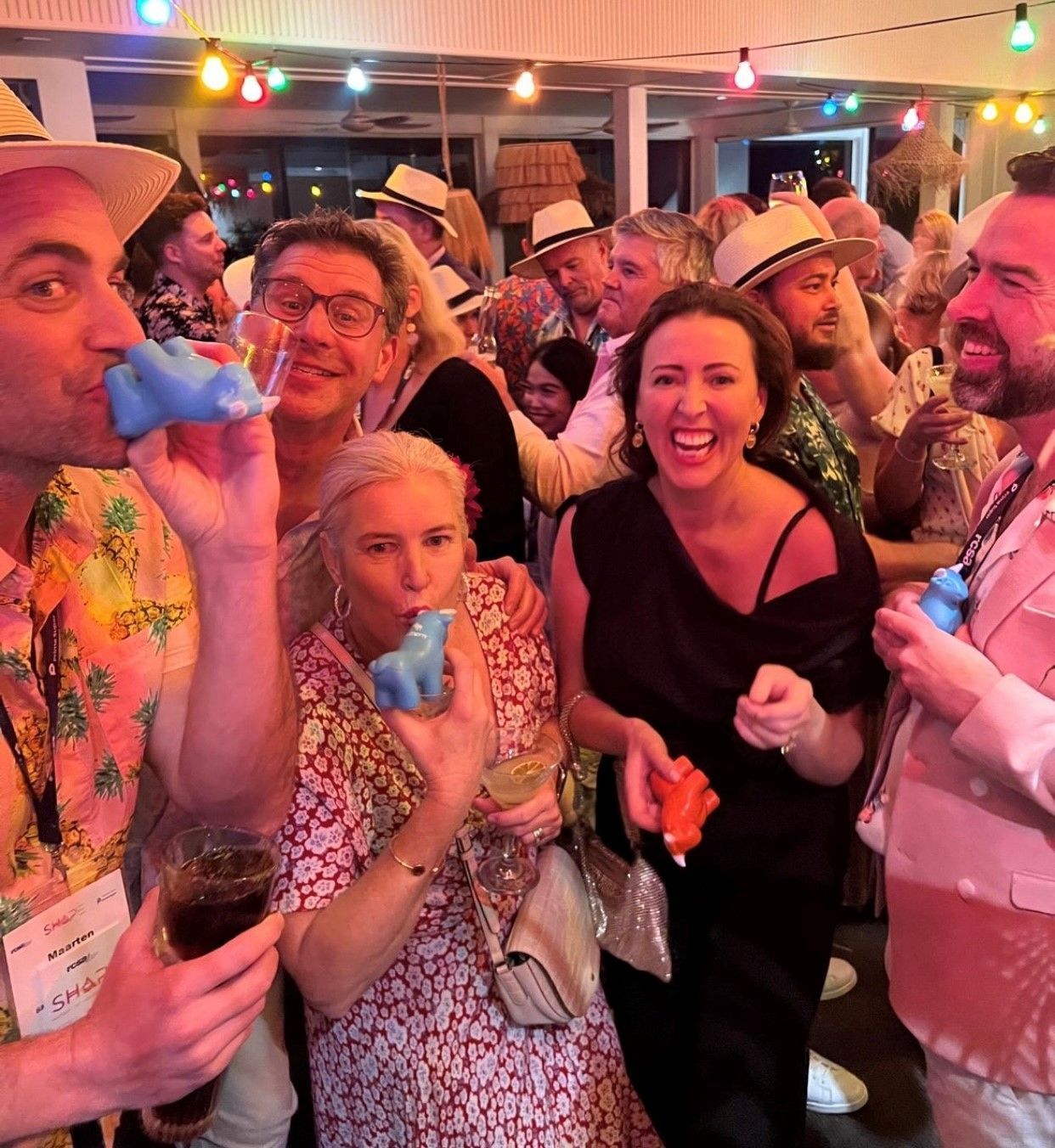 A group of people are standing in a room drinking