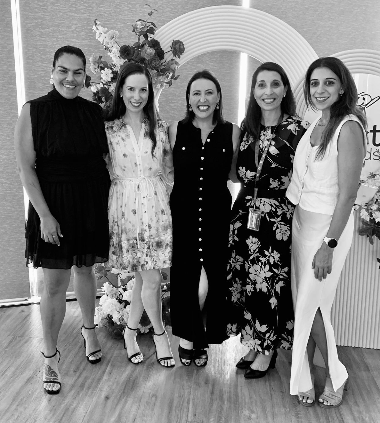 A group of women are posing for a picture together in a black and white photo.