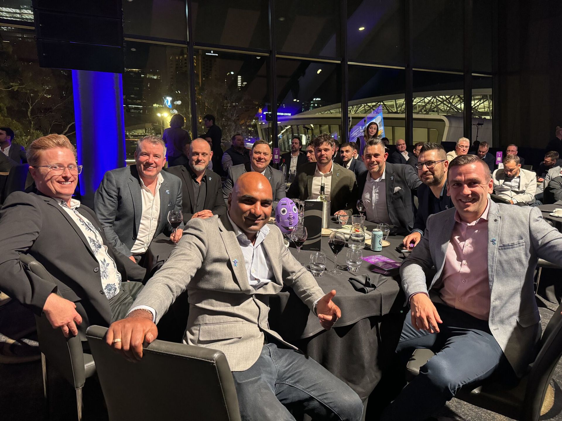 A group of men are posing for a picture at a dinner party.