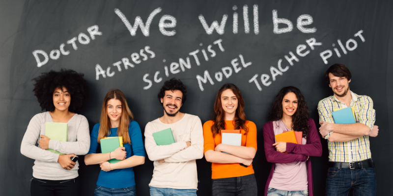 A group of people standing in front of a blackboard with the words we will be written on it.