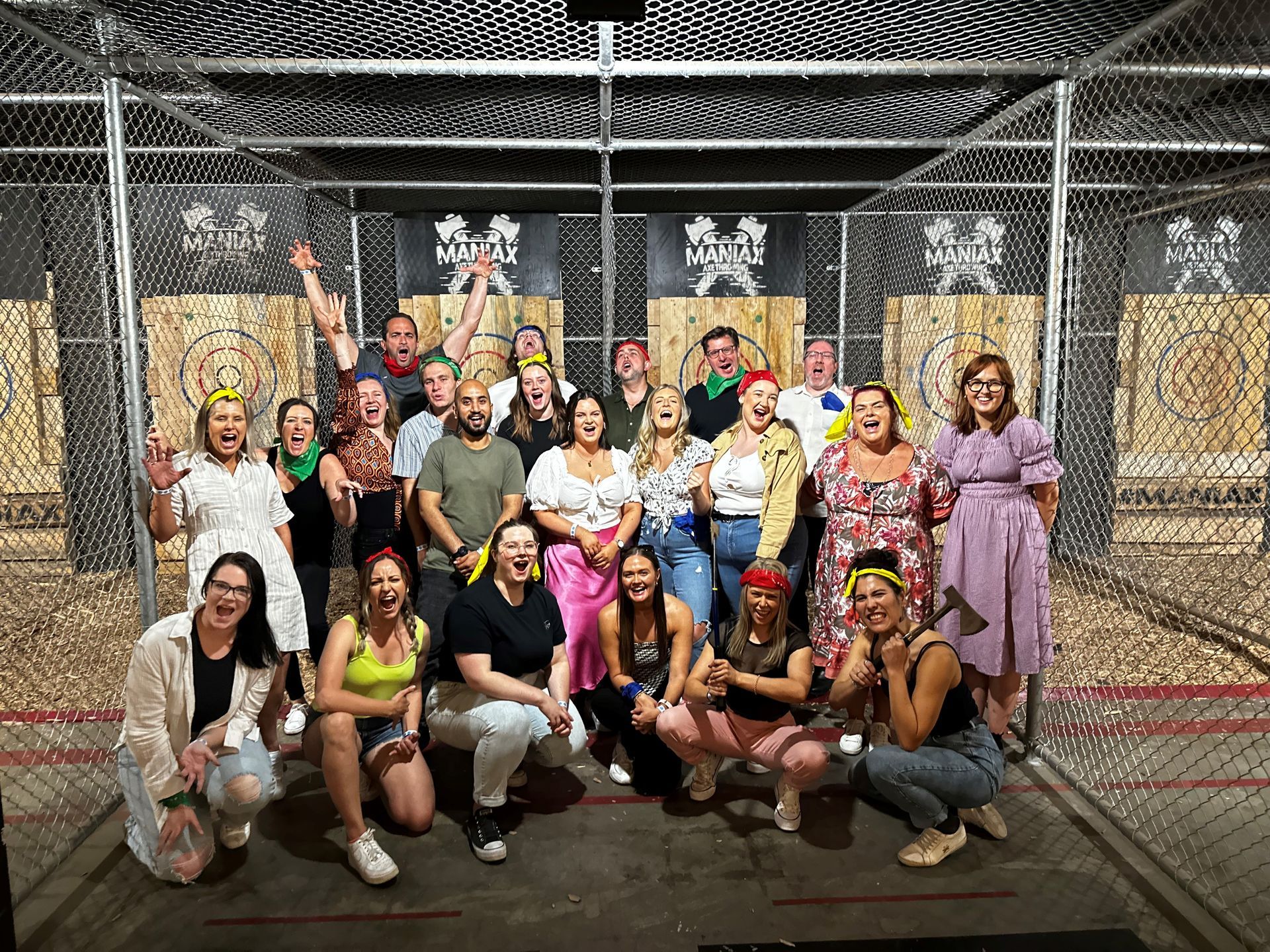 A group of people are posing for a picture in front of axes.