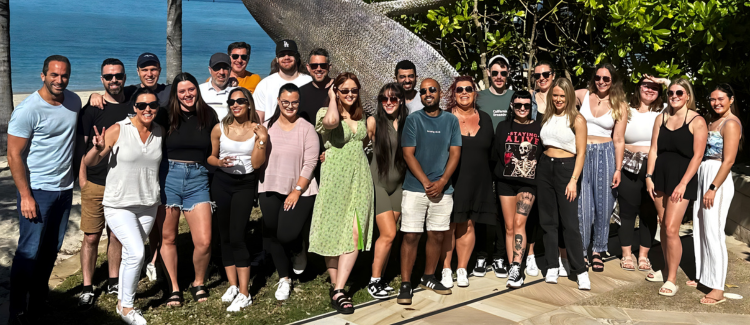 A large group of people are posing for a picture in front of a statue.