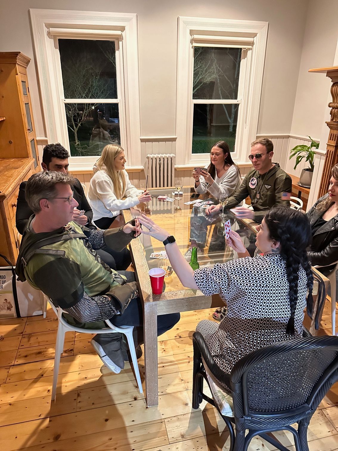 A group of people are sitting around a table drinking wine.