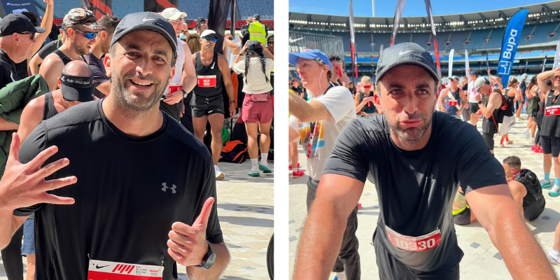 Two men are posing for a picture at a marathon.