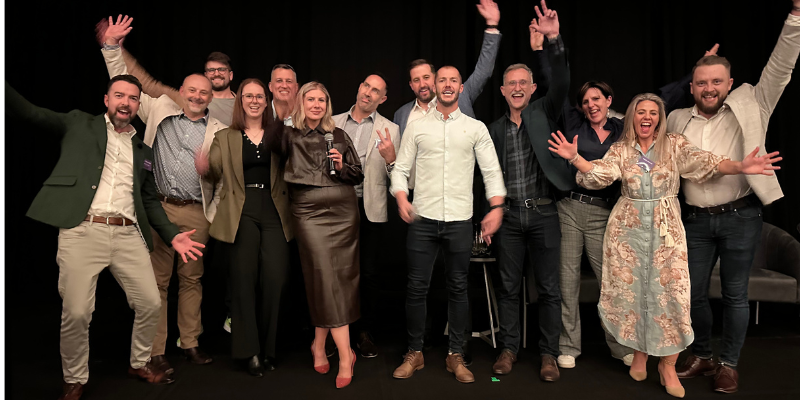 A group of people are posing for a picture with their arms in the air.