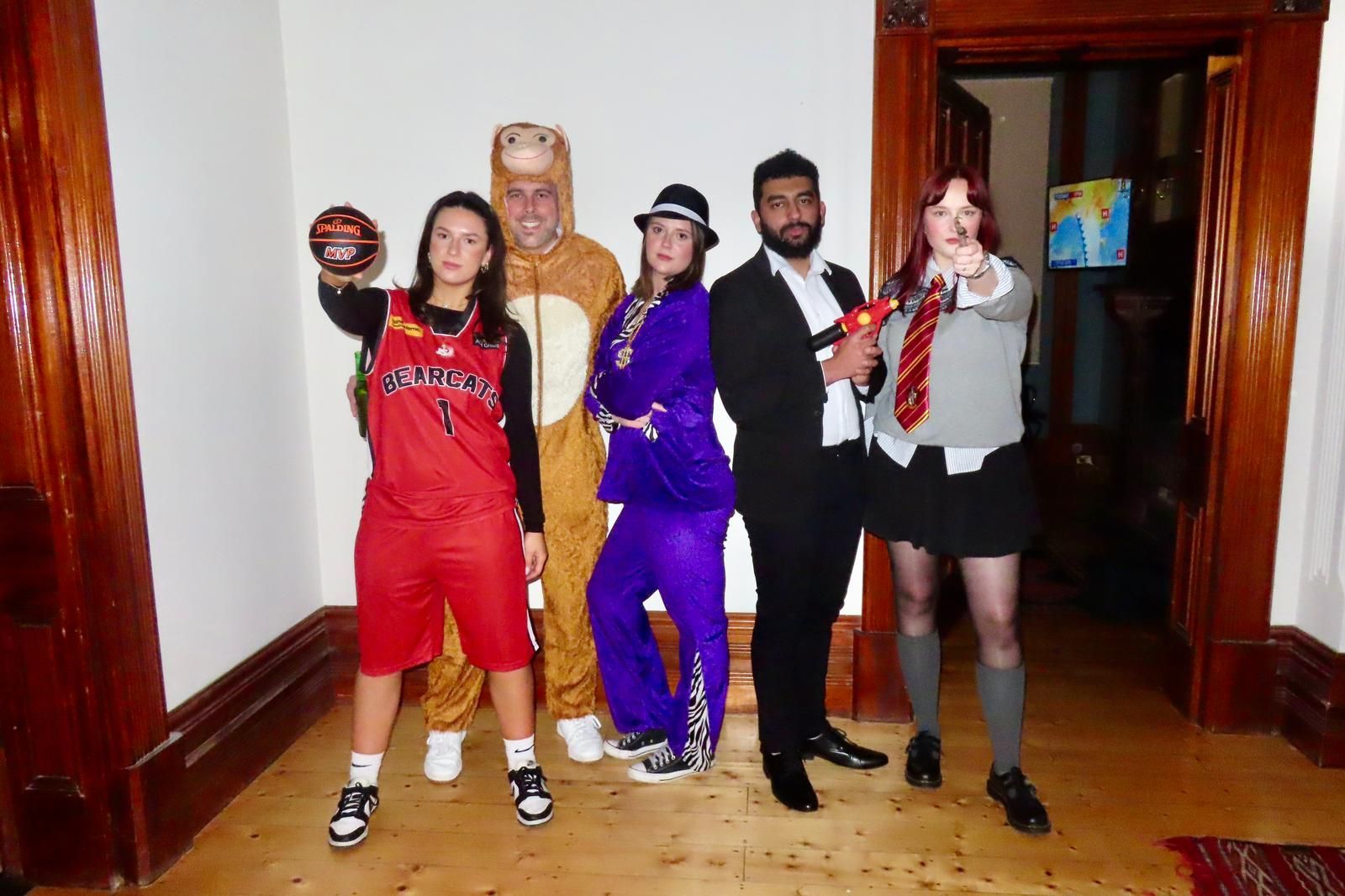 A group of people dressed in costumes are posing for a picture.
