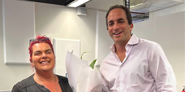 A man and a woman are standing next to each other and smiling.