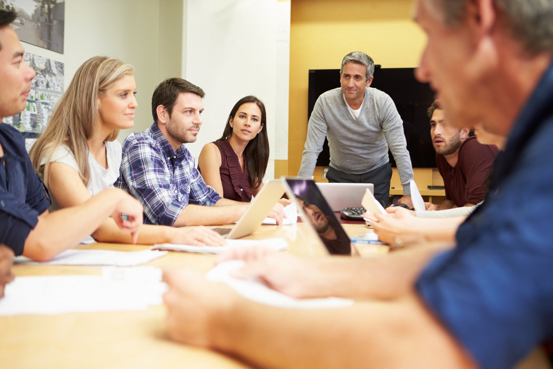 A group of people are sitting around a table having a meeting.