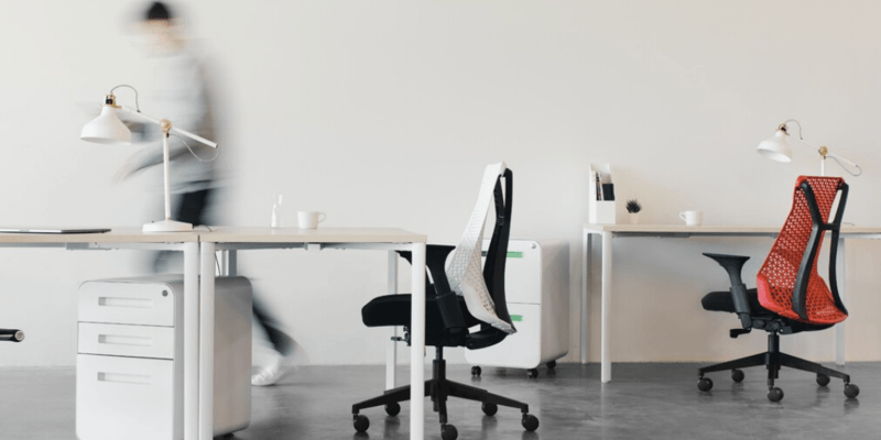 A blurry picture of a person walking in an office.