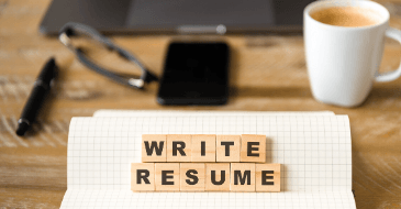 A notebook with the words `` write resume '' written on it.