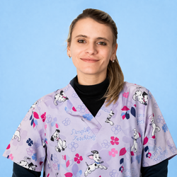 Donna in camice con motivo lavanda sorride su uno sfondo azzurro chiaro