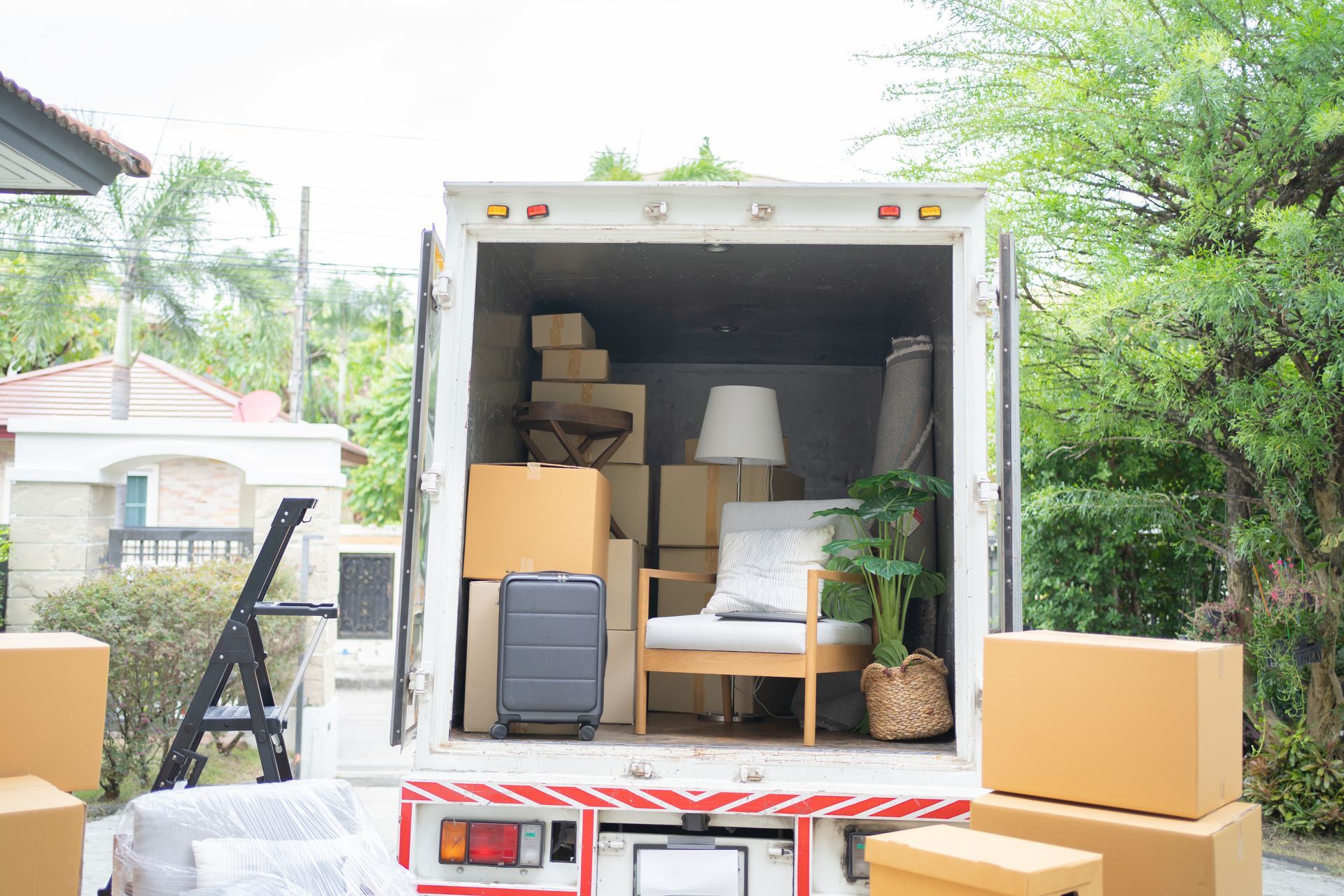 Furniture and boxes being loaded into a moving truck outdoors