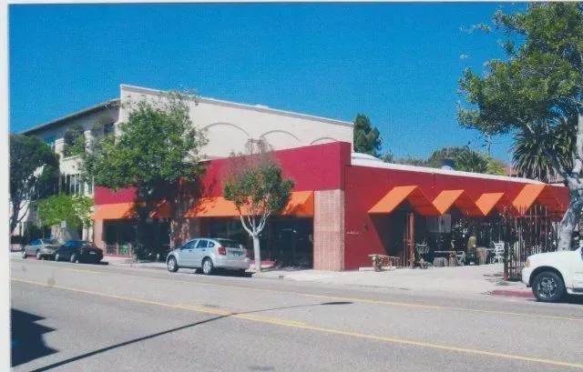 A white truck is parked in front of a red building