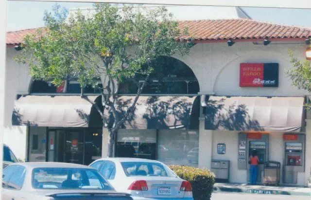 A picture of a bank with cars parked in front of it