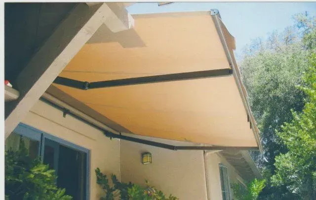 A house with a yellow awning on the side of it