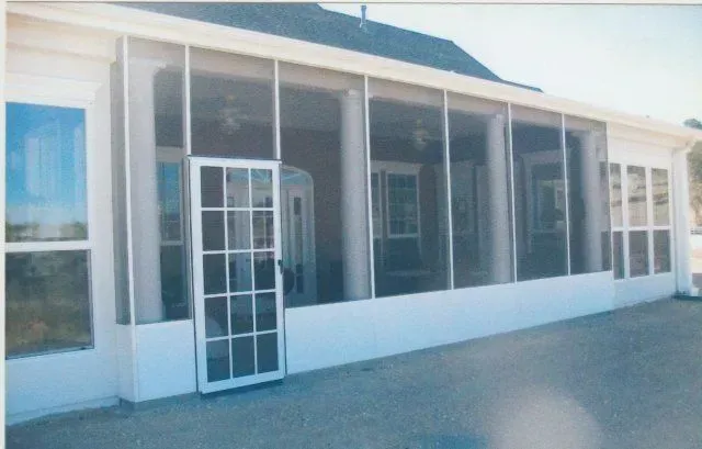 A screened in porch with a door and windows