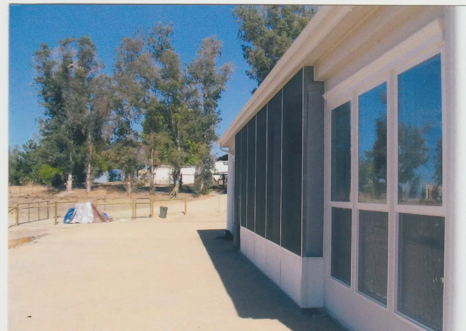 A picture of a screened in porch with trees in the background