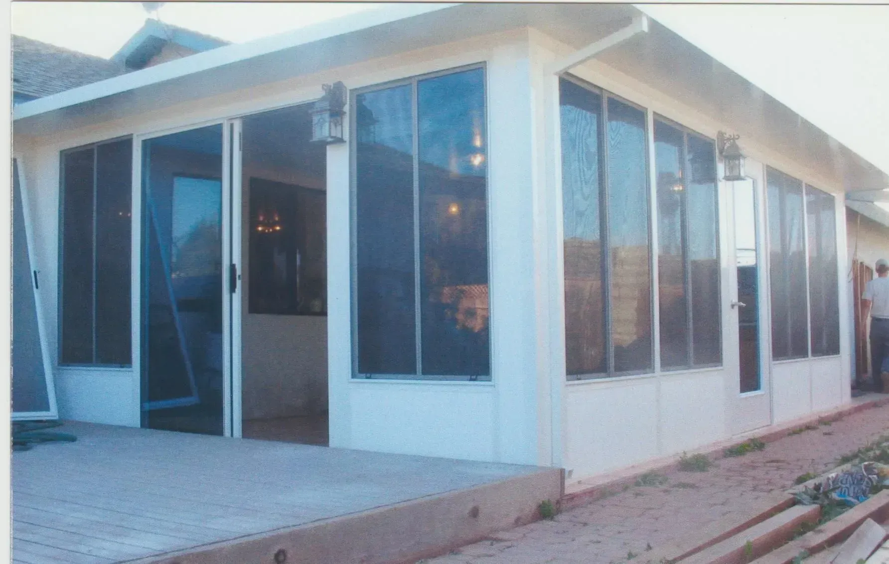 A house with a screened in porch and sliding glass doors