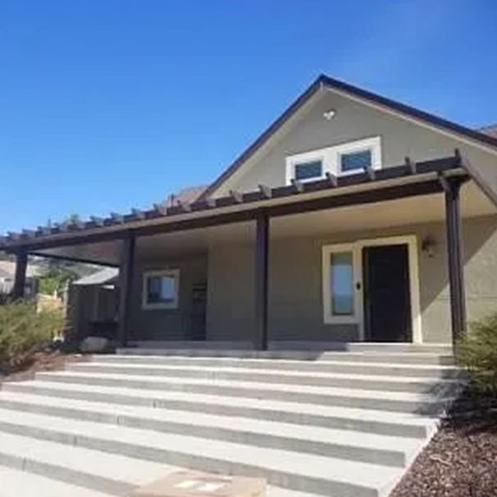 A house with stairs leading up to it and a porch. A house with stairs leading up to it and a porch.