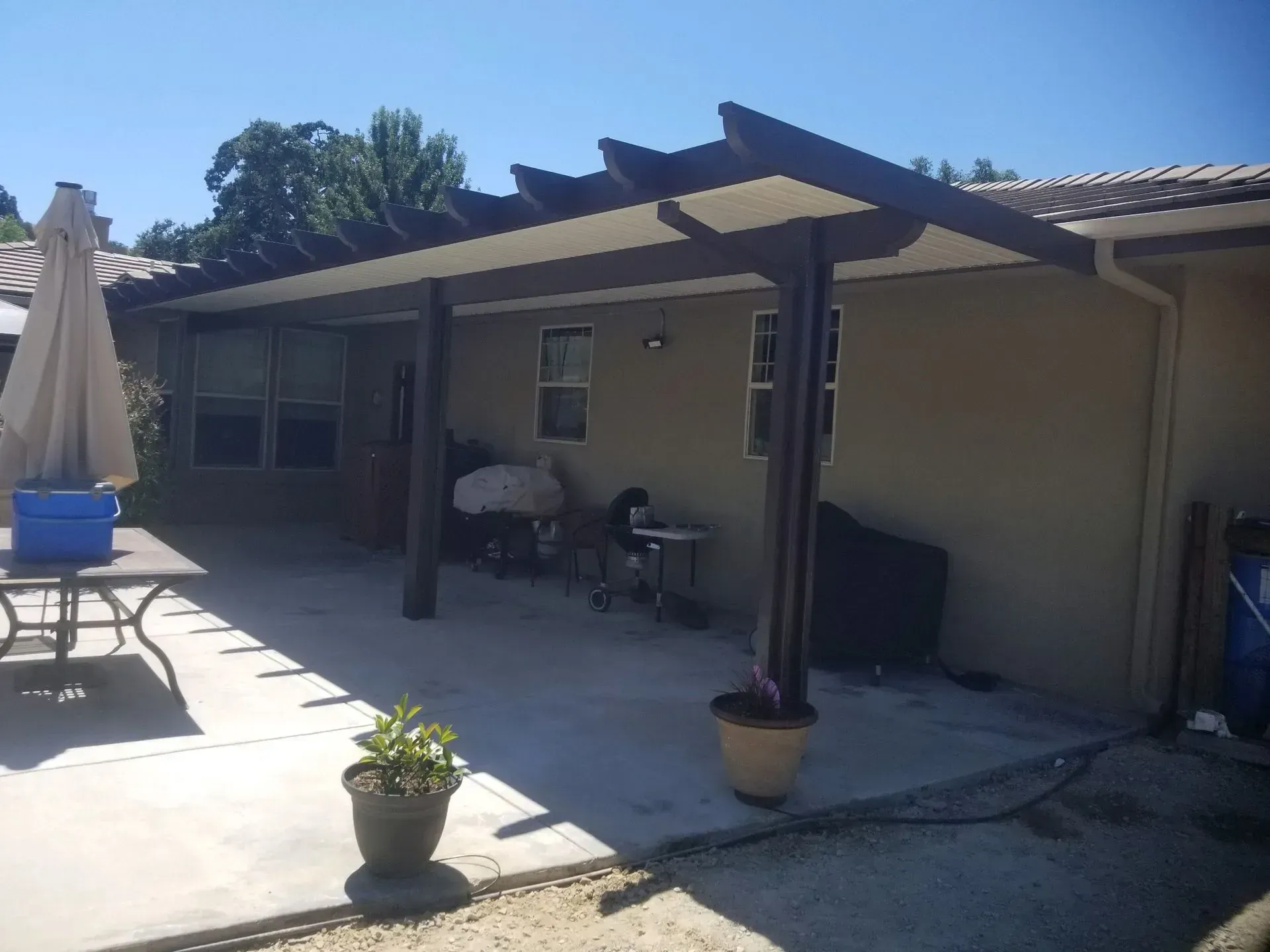 A patio with a table and chairs under a pergola.