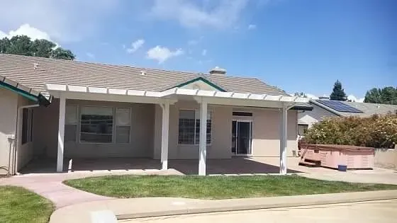 A house with a covered porch and a solar panel on the roof.