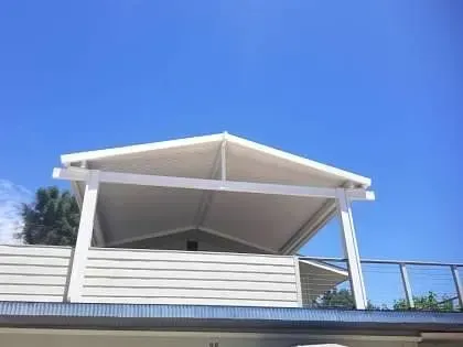 A white house with a white roof and a balcony.