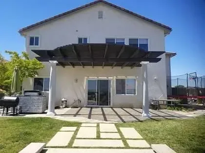 A pergola with a table and chairs underneath it