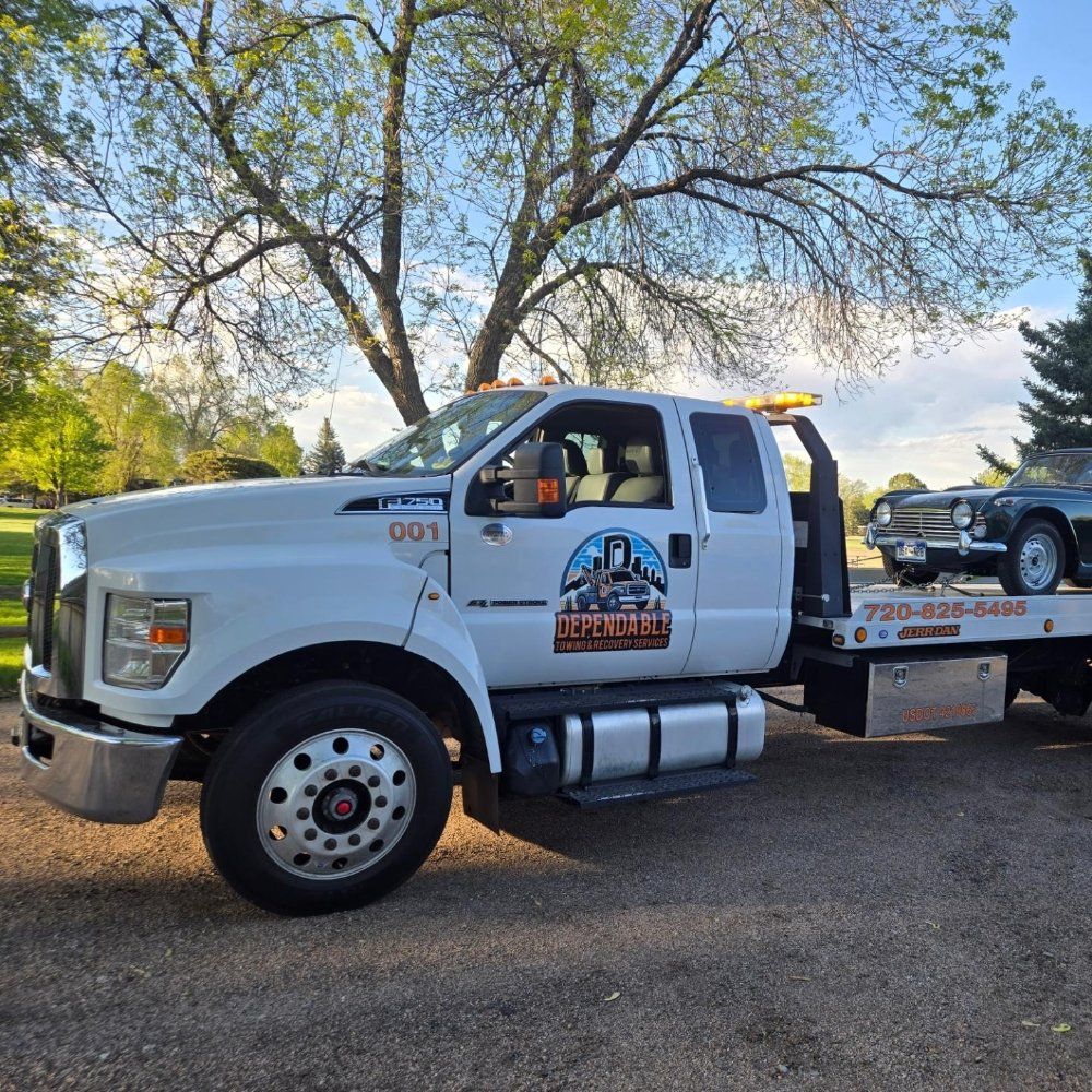 A white flatbed tow truck with the 