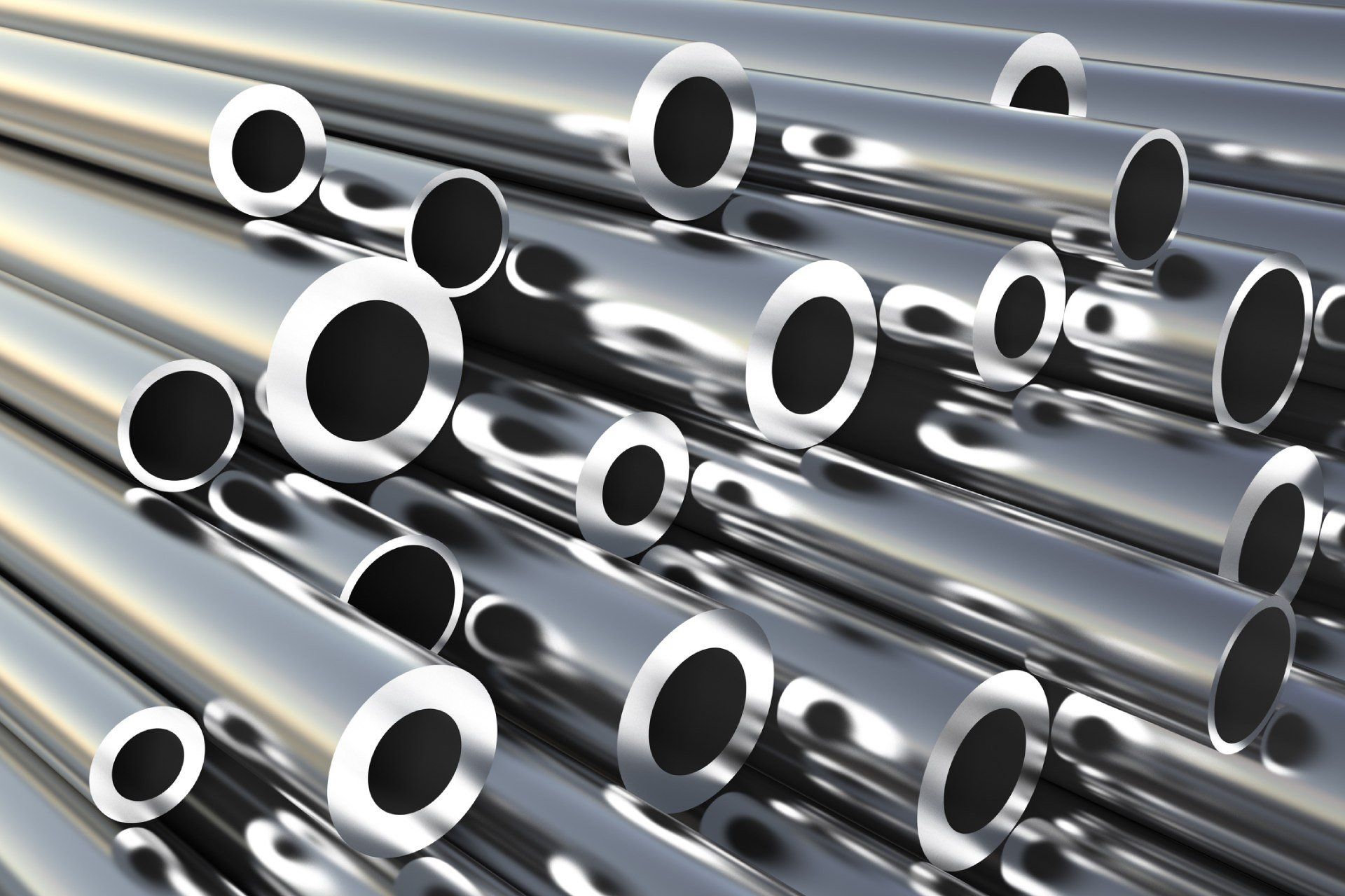 Tubi metallici lucidi impilati insieme, che riflettono la luce.