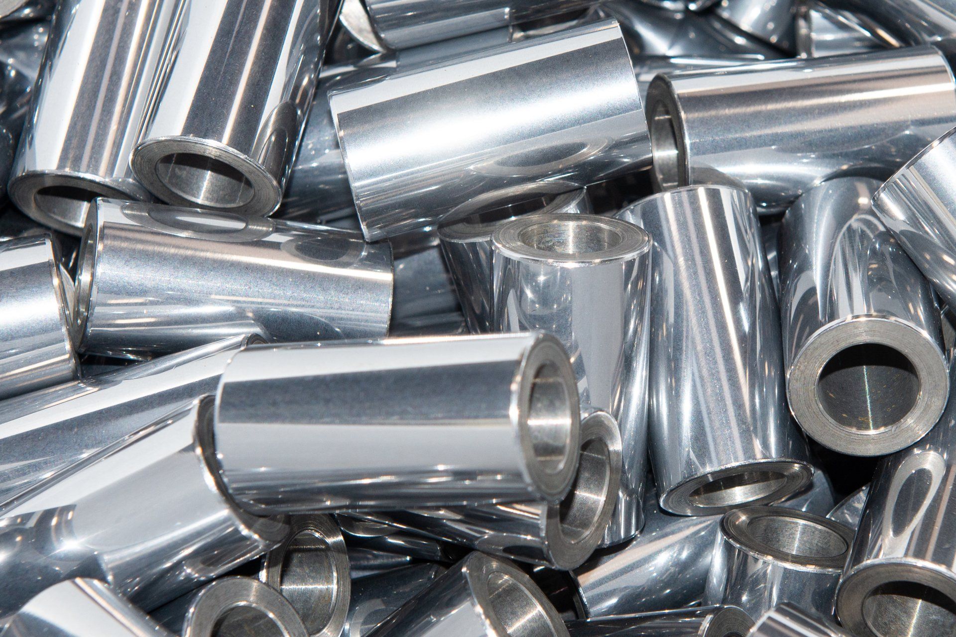 Oggetti metallici cilindrici e lucenti ammucchiati insieme.