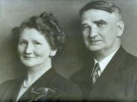 A man and a woman are standing next to each other in a black and white photo.