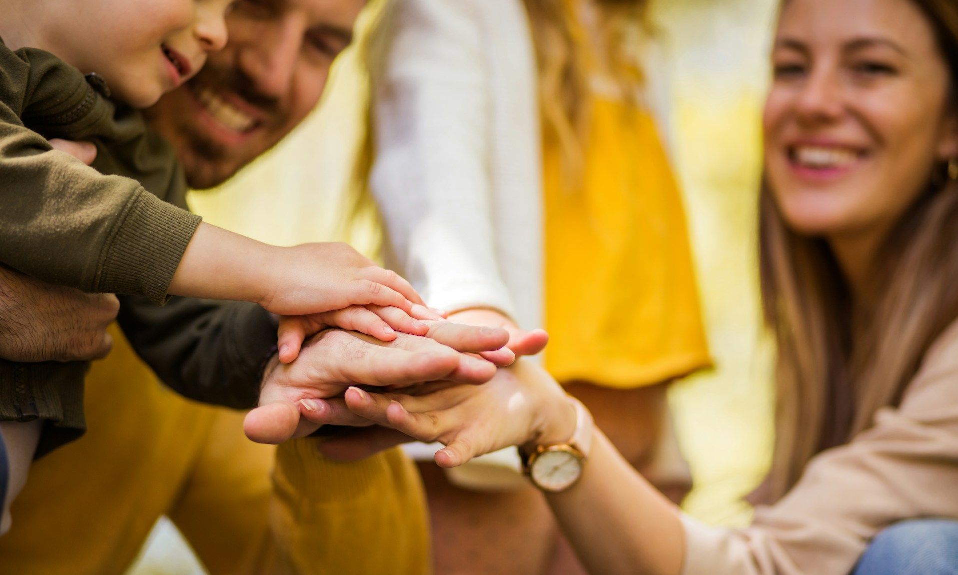 A family is putting their hands together in a stack.