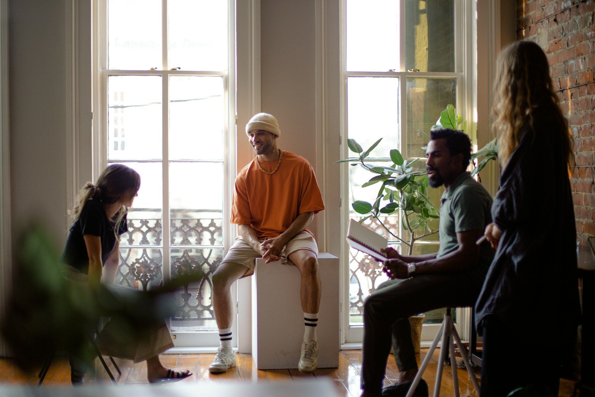 A group of people are sitting in a room talking to each other.