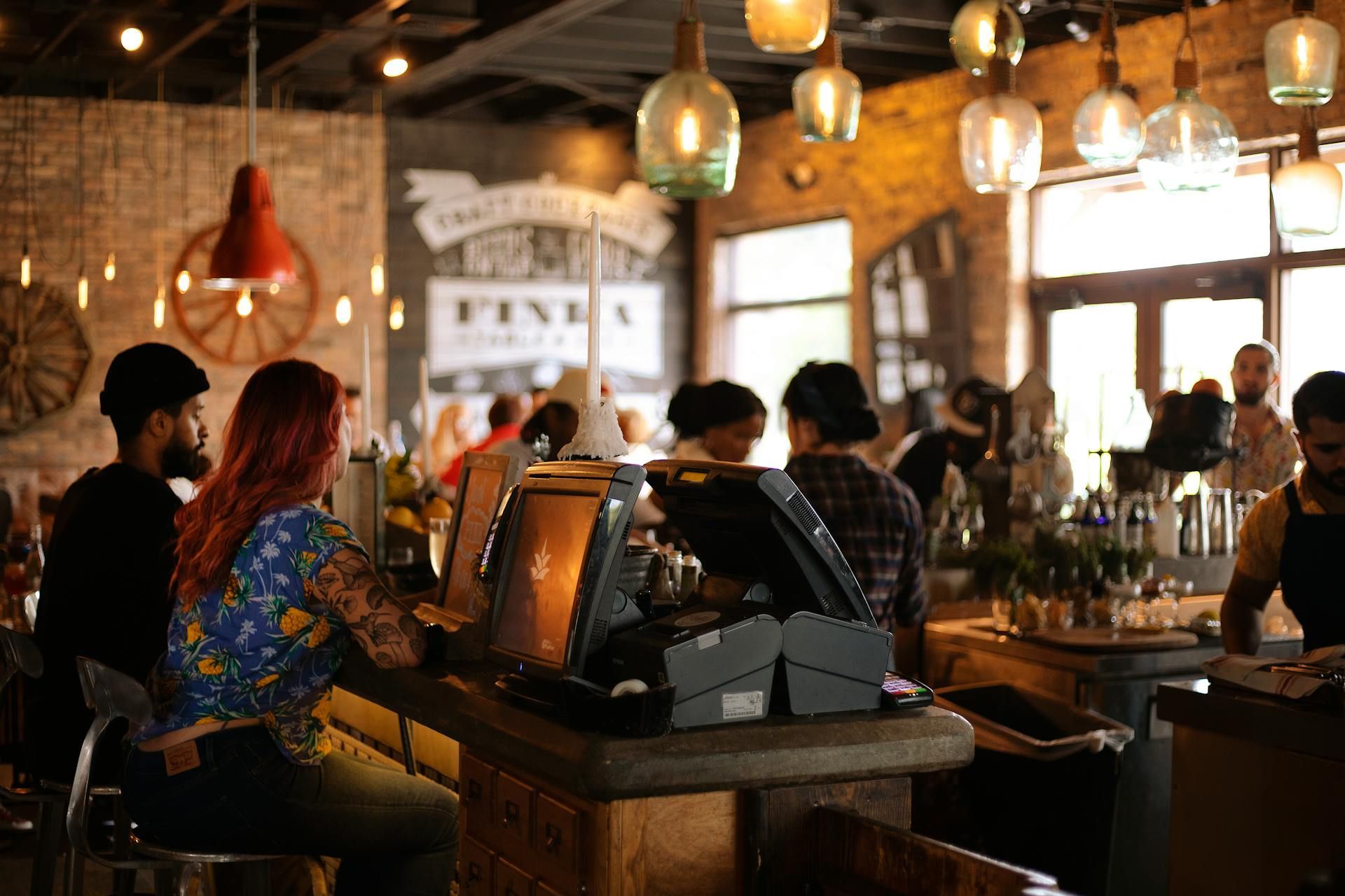 A group of people are sitting at tables in a restaurant.