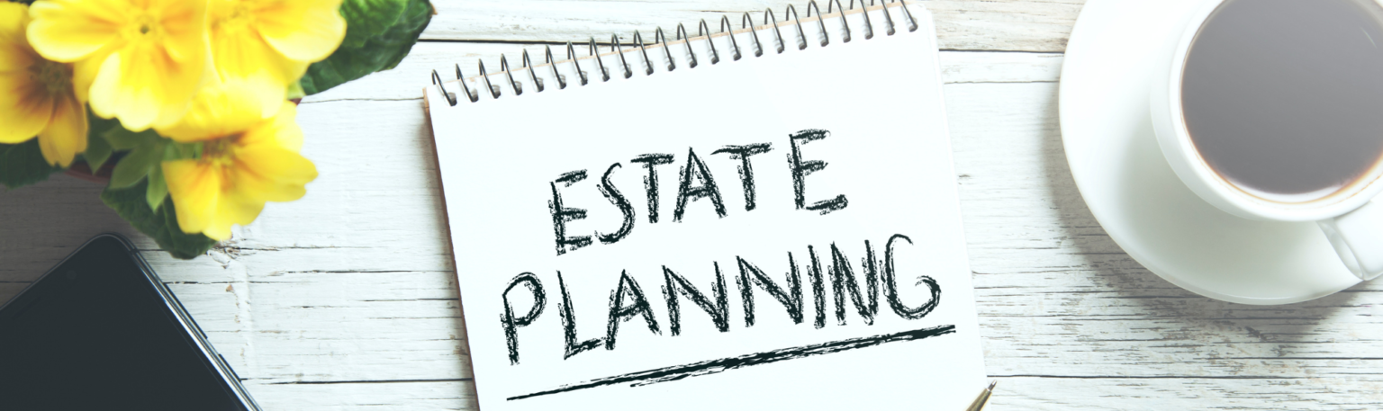 Notebook on a white wooden table with the words “Estate Planning” and a cup of coffee. Yellow flowers are on the left.