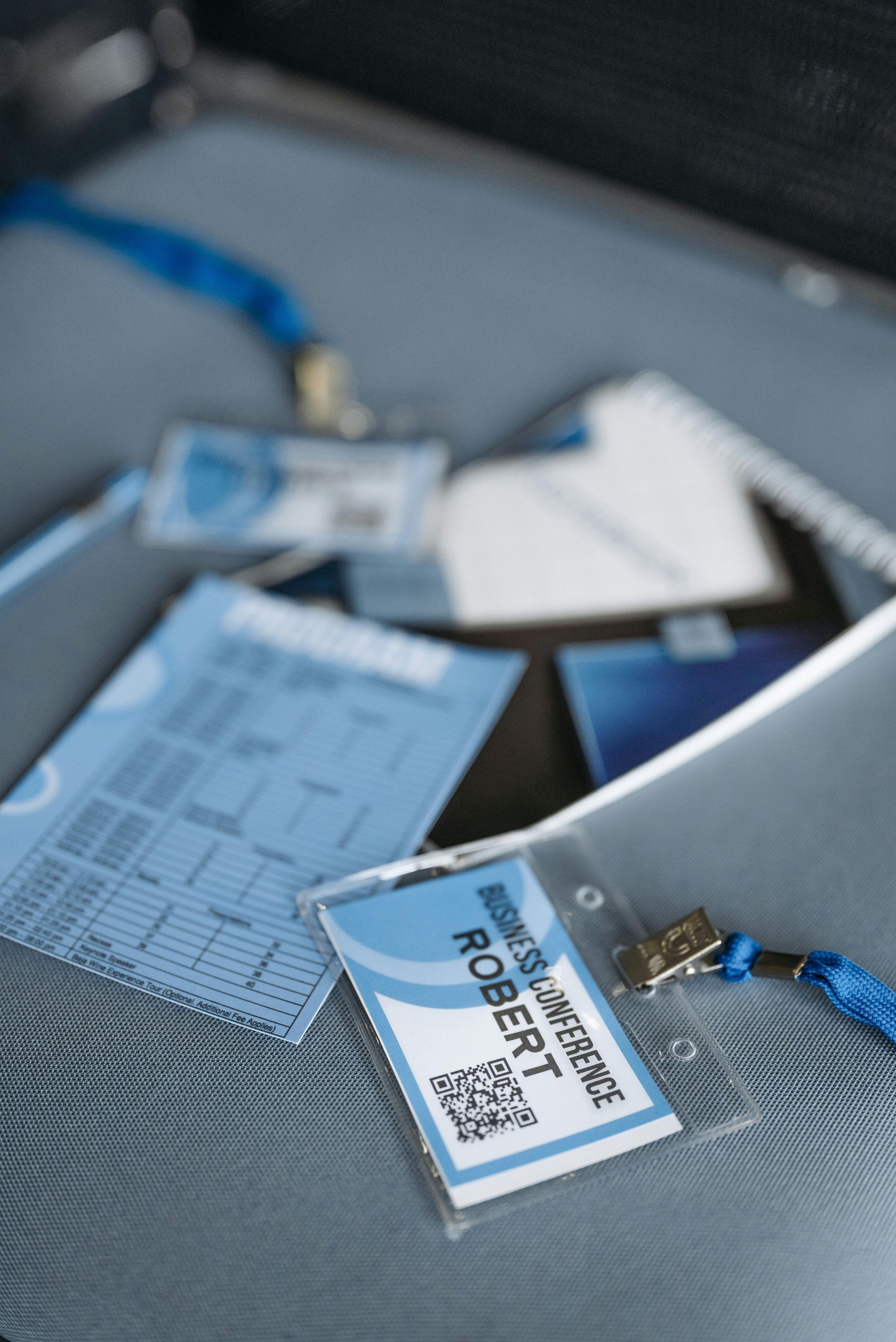 A close-up of conference badges and papers with blue accents, including one labeled