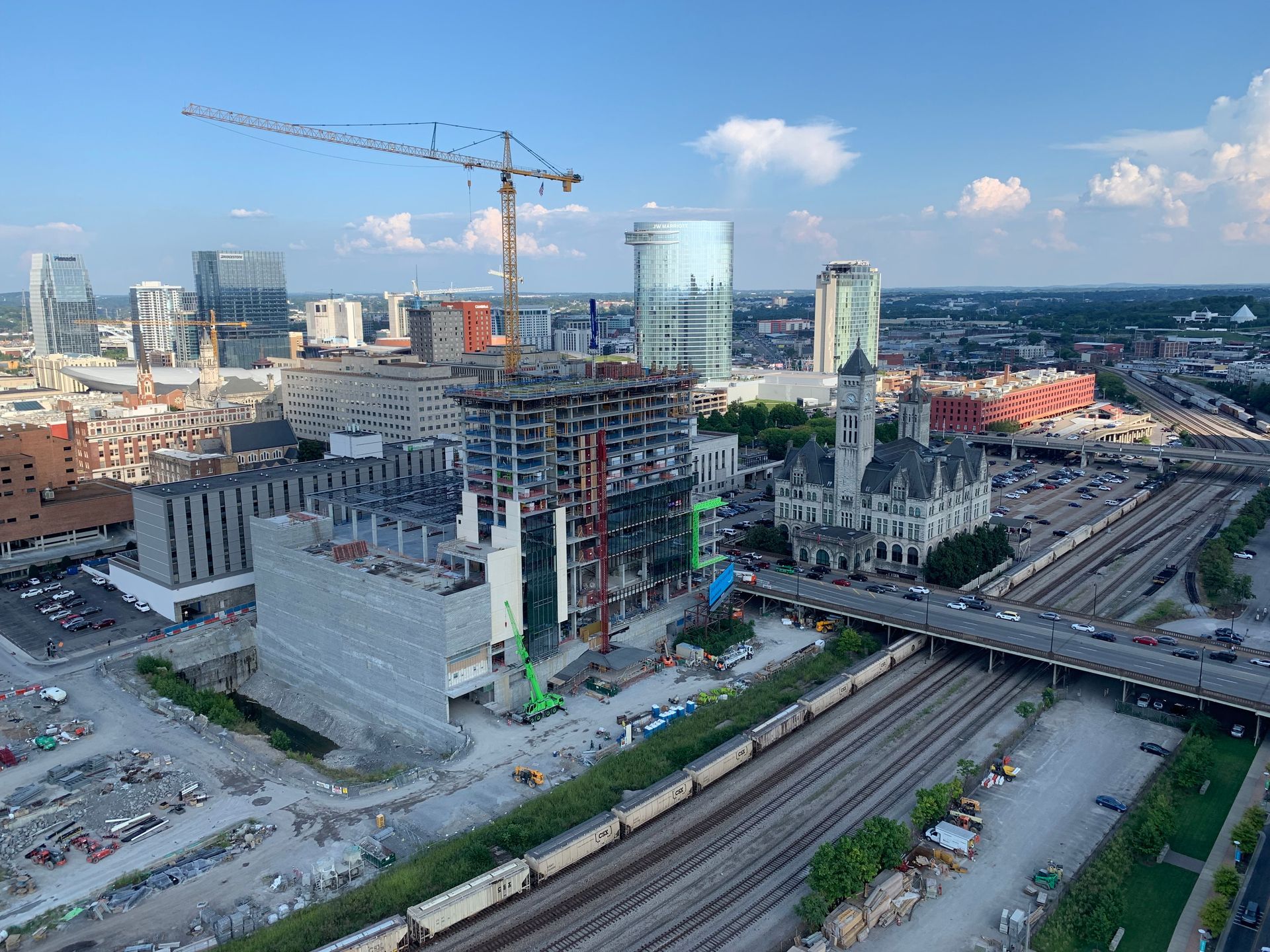 An aerial view of a city under construction with a crane in the foreground.