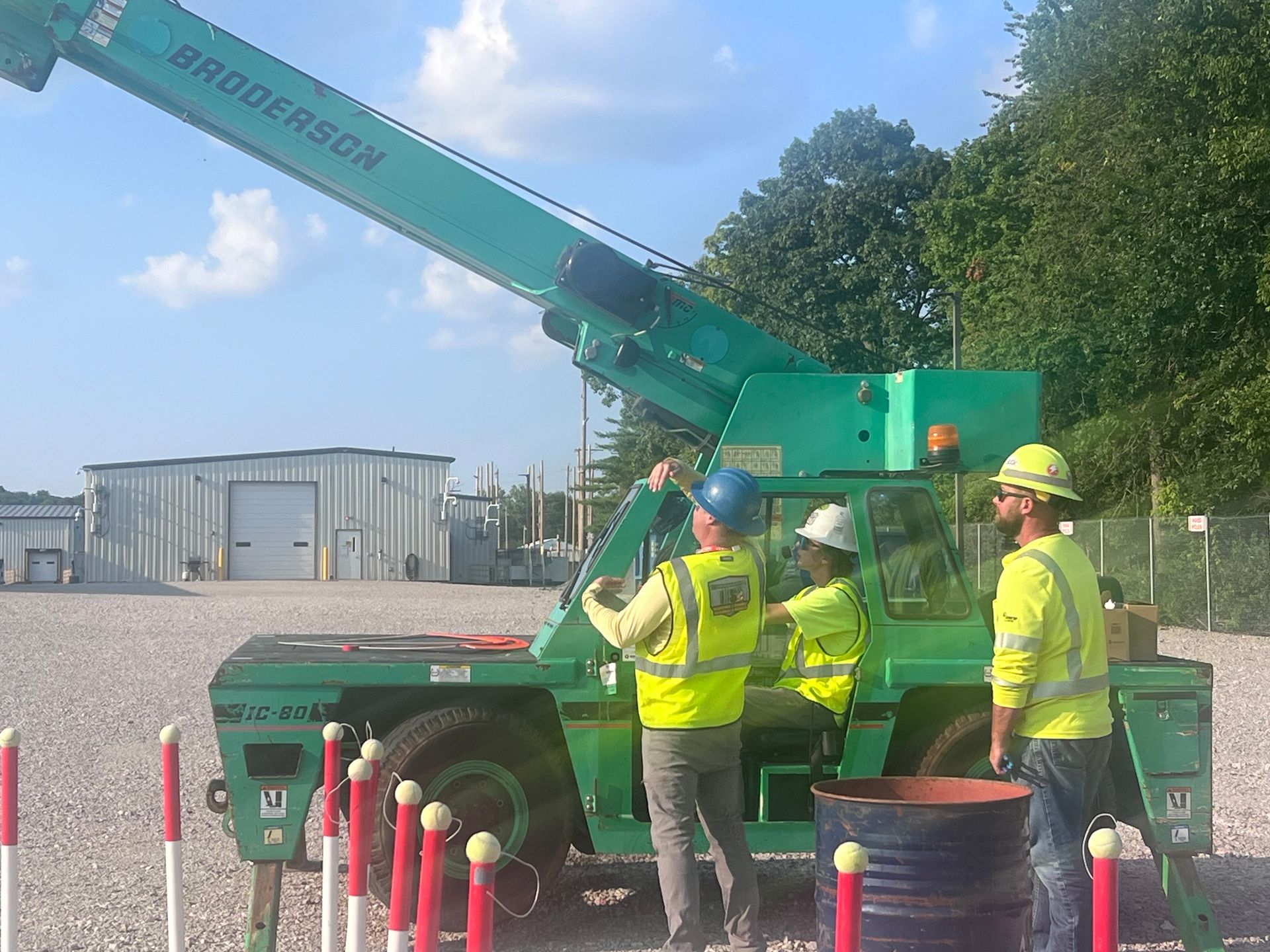 A green crane is parked in a warehouse.