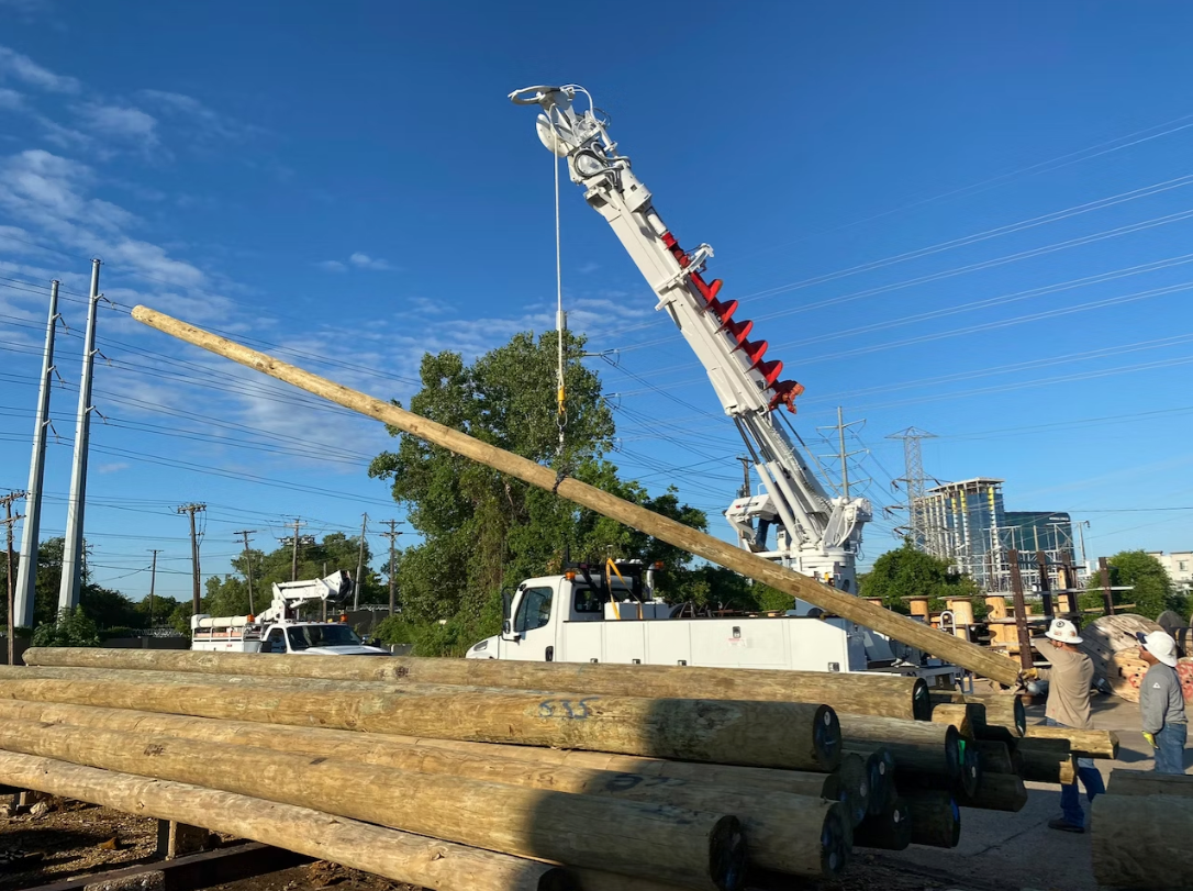 A large crane is lifting a large piece of wood