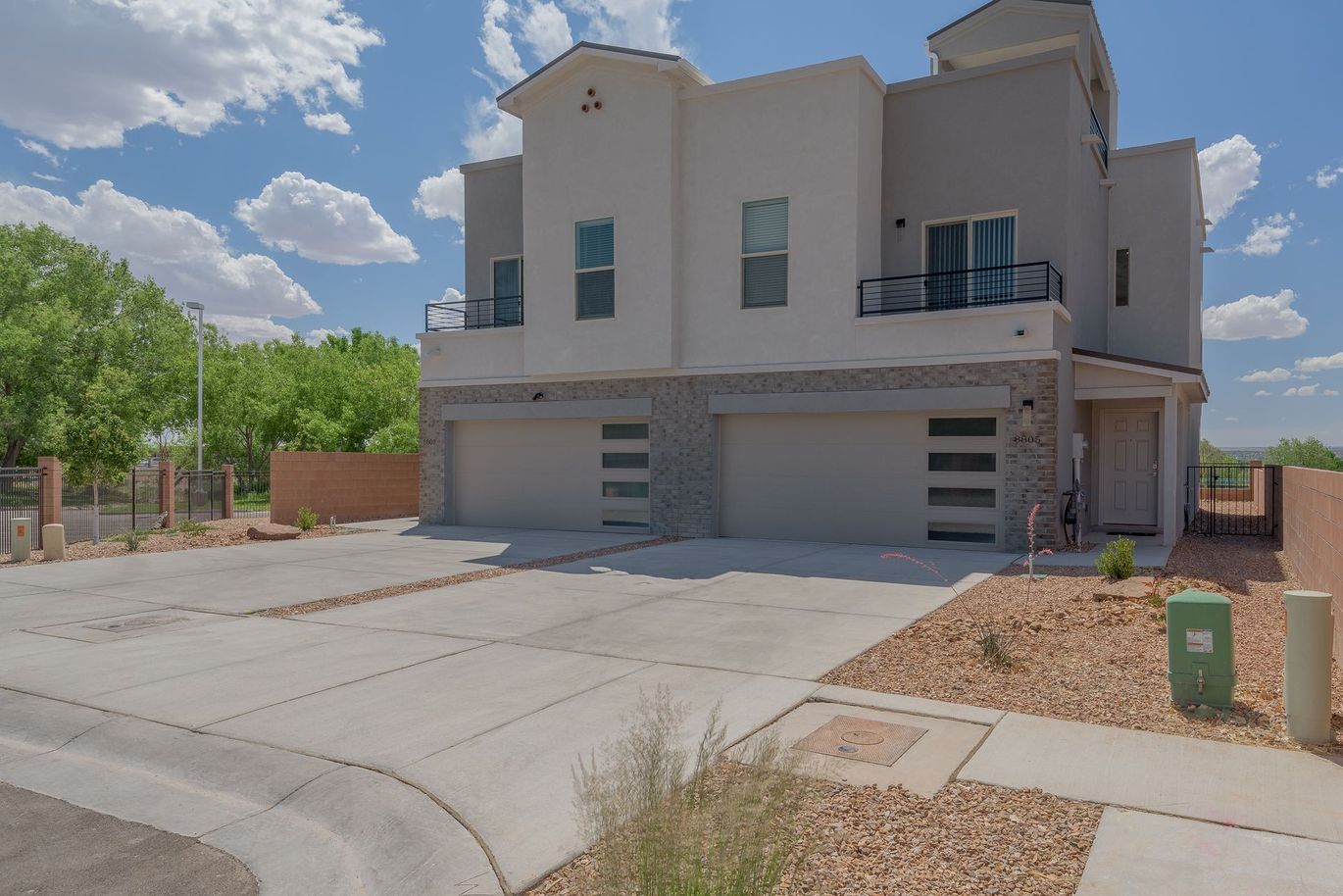 A large white house with three garages and a concrete driveway