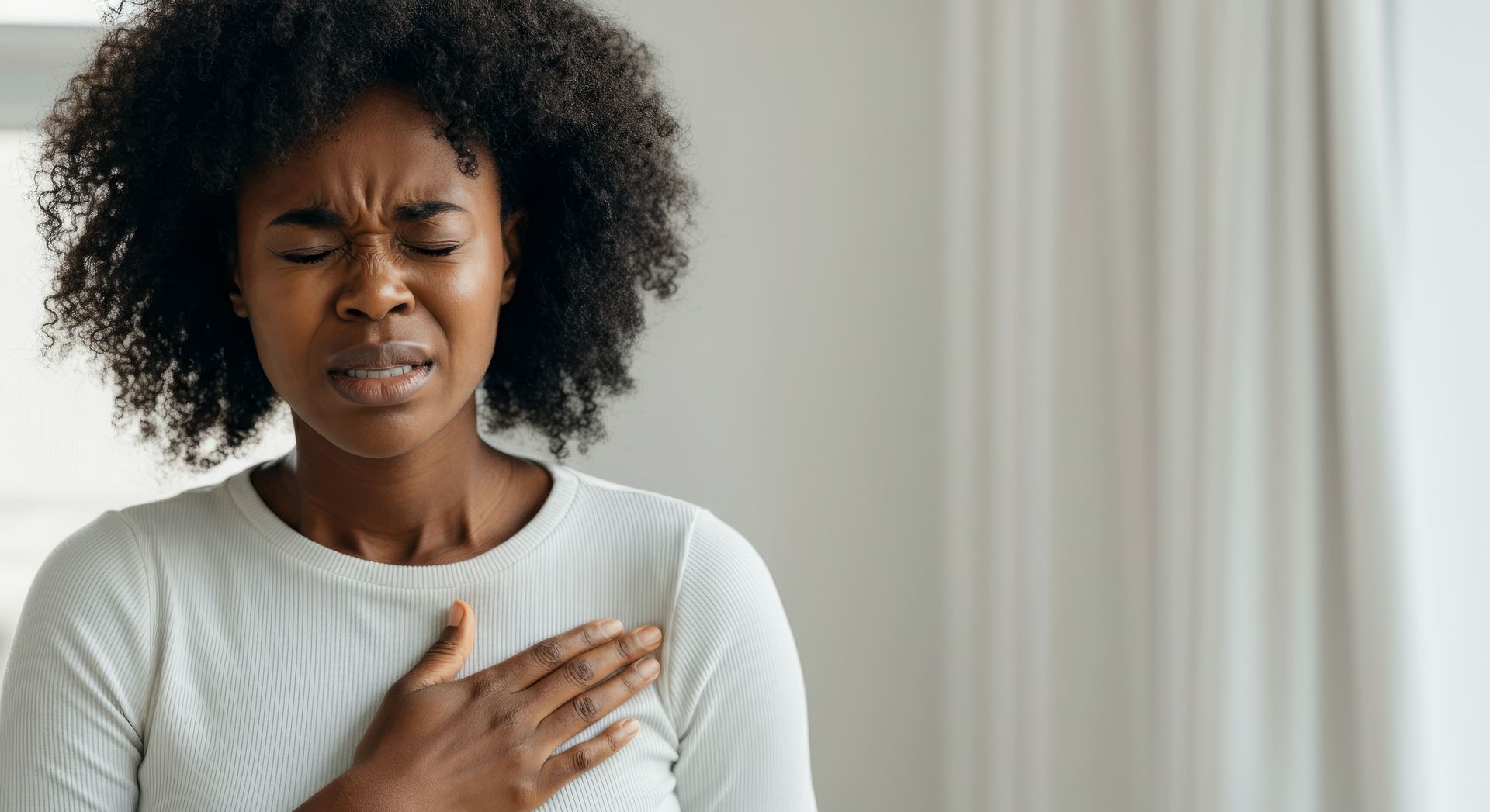 Uma mulher está segurando o peito com dor.