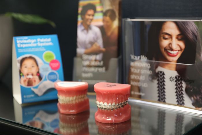 A display of braces and a picture of a smiling woman